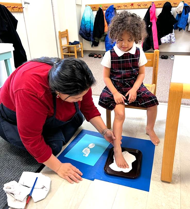 Child get their foot print stamped for a craft